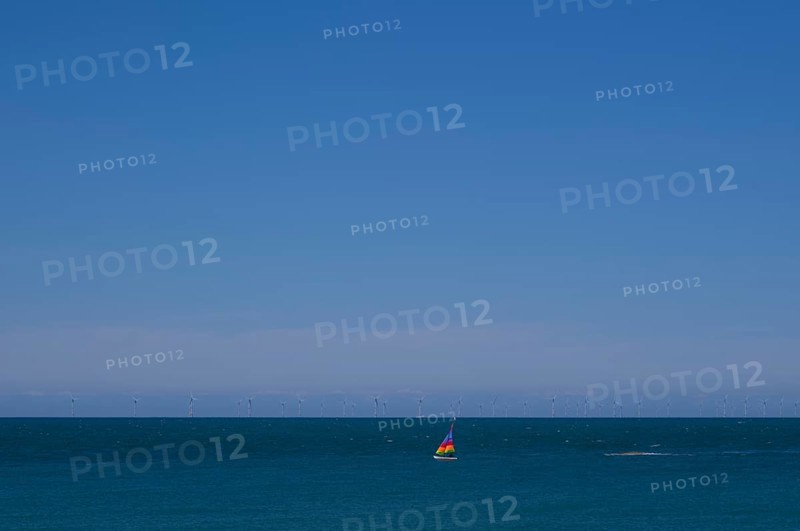Sailboat, colourful sail, sailing on sea, sky, blue, behind offshore wind farm, wind turbines, Étretat, Normandy, Seine-Maritime, France