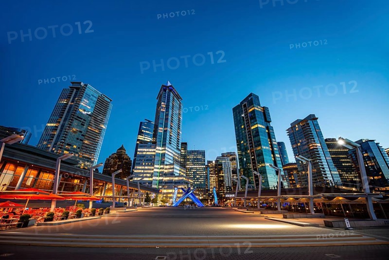 Illuminated skyscrapers on the promenade in the evening, Olympic Cauldron Statue, Jack Poole Plaza Square, Blue Hour, Coal Harbour, Vancouver, British Columbia, Canada