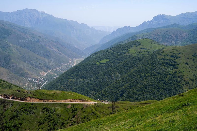 Panoramic view of a valley with road and green hills between mountains, view of Lernadzor surrounded by the mountains of the Zangesur Range, Sangesur, Syunik province, Caucasus, Armenia