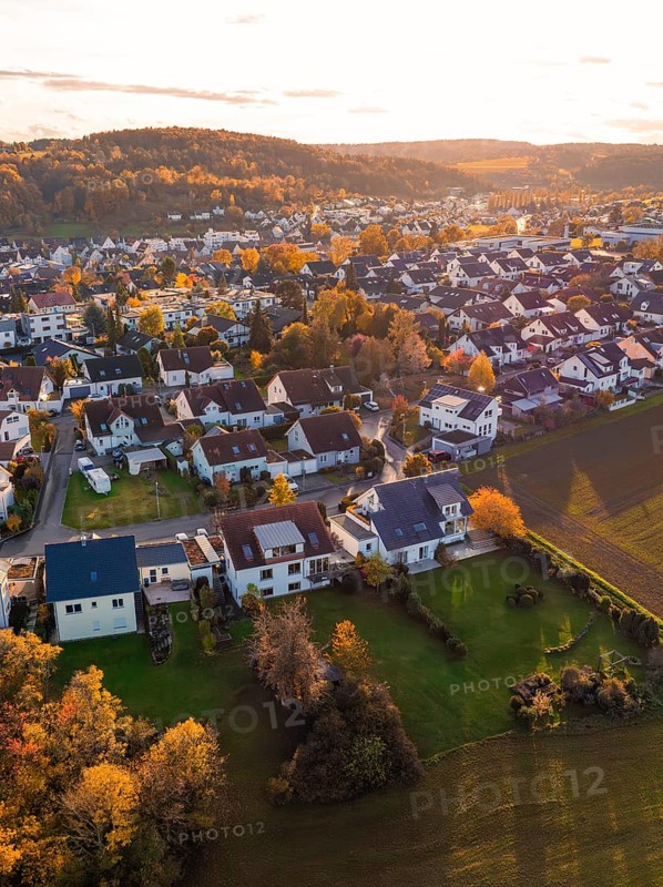 Near settlement with autumn trees and roofs, illuminated by golden sunlight, Aidlingen, Böblingen district, Germany