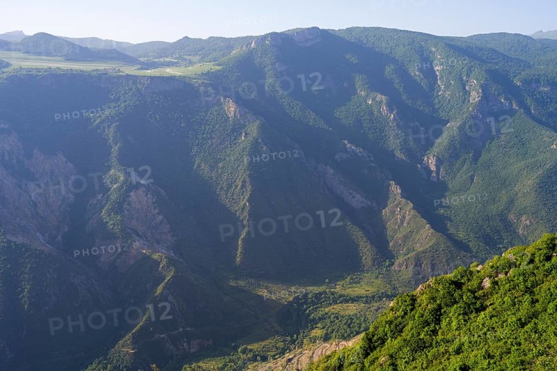 Green, wooded mountain slopes in the sun surrounding vast valleys, view of the Vorotan River valley, Vorotan, Halidzor, Syunik province, Caucasus, Armenia