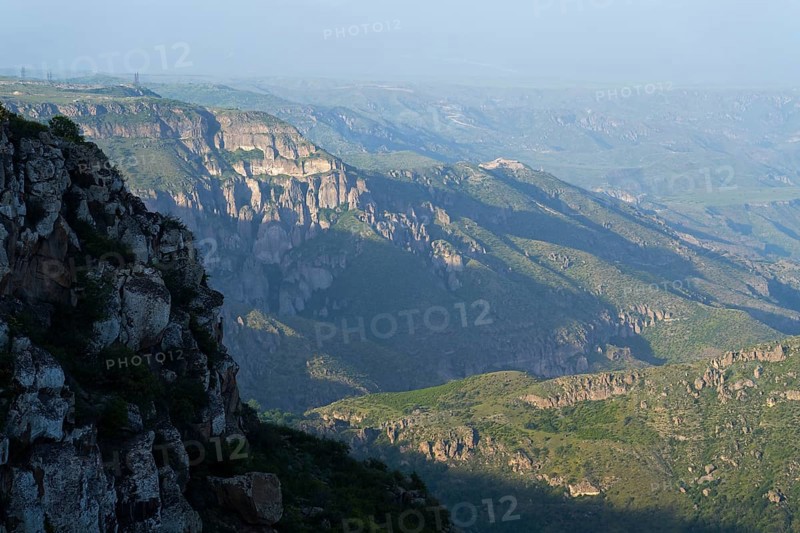 Wide view of rocky gorges and green slopes under a blue sky, view of the Vorotan River valley, Vorotan, Halidzor, Syunik province, Caucasus, Armenia