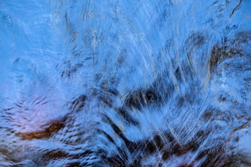 Shimmering blue water surface of a stream, current, light reflections, abstraction, long exposure, Sweden