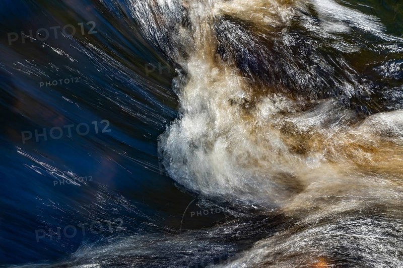 Stream flow with dark water, reflections and turbulences, long exposure, Sweden
