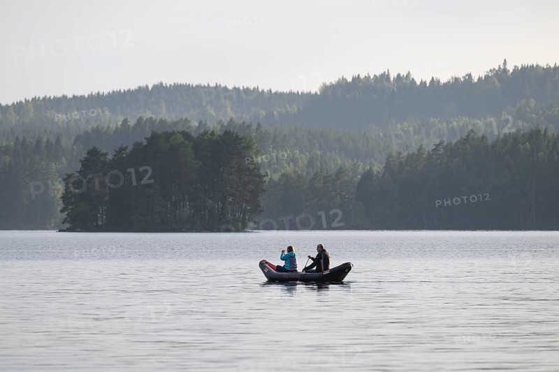 Paddler, lake surrounded by forest, near Sunne, Sweden