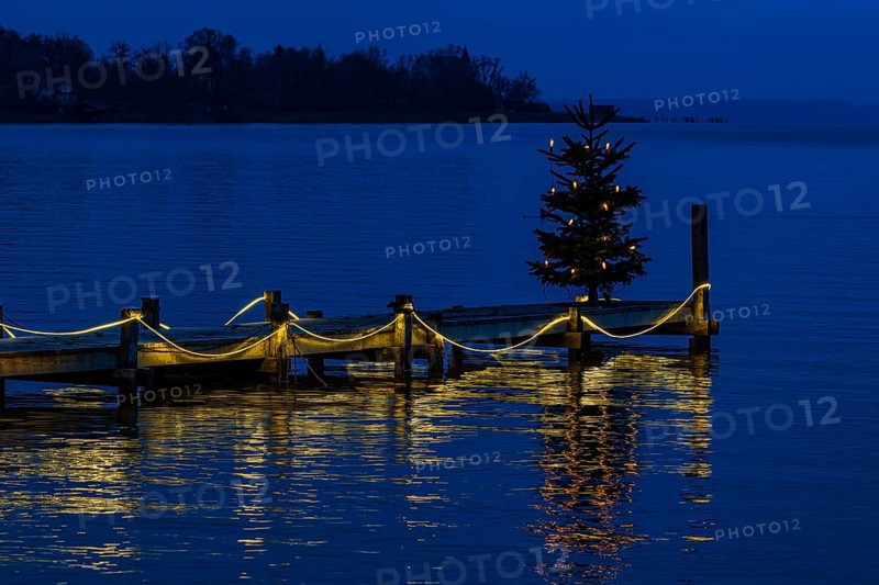 Illuminated Christmas tree at dawn, on an illuminated boat dock, Dießen am Lake Ammer, Upper Bavaria, Bavaria, Germany