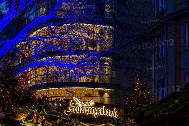 Sales stand for Feuerzangenbowle, above a deciduous tree illuminated with blue light, Christkindlmarkt, Rindermarkt, Munich, Upper Bavaria, Germany