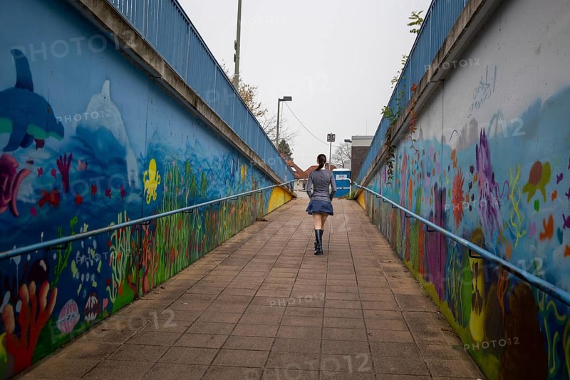 (Photo montage) Young woman at the end of a dark underpass