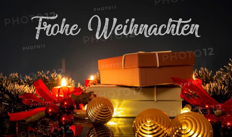 Christmas greetings: table with Christmas decoration and gifts against a blue background with inserted lettering MERRY CHRISTMAS