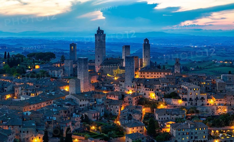 City view of San Gimignano at dusk, gender towers and medieval buildings, Tuscany, Italy