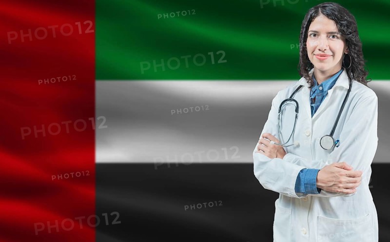 Emirati medicine and healthcare concept. Close up of doctor against United Arab Emirates flag background