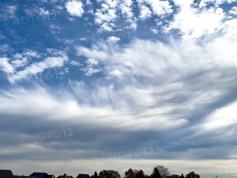 Above white medium-height clouds Altocumulus floccus below Altostratus with gray underside in front of top blue sky, international