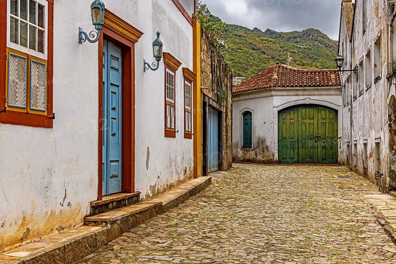 Alley with old colonial-style houses and sunlit cobblestones in the historic city of Ouro Preto in Minas Gerais, Brasil