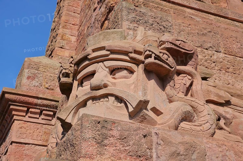 Warrior's face with snake figure and dragon at the Kyffhäuser monument, detail, figure, stone, red, face, Kyffhäuser monument, Kyffhäuser, Thuringia, Germany