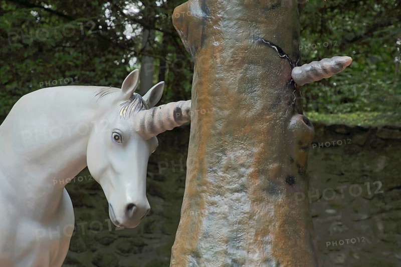 Horn of a unicorn in fairy tale The brave little tailor forcefully pierces a tree trunk, sculpture, fairytale figure, pierce, stick through, look out, stick through, stick through, in, white, detail, symbol, castle park, Lichtenwalde, Niederwiesa, Saxony, Germany