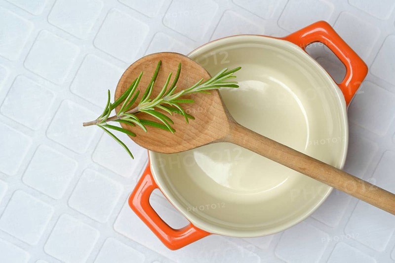 Rosemary, rosemary sprig on cooking spoon with cooking pot