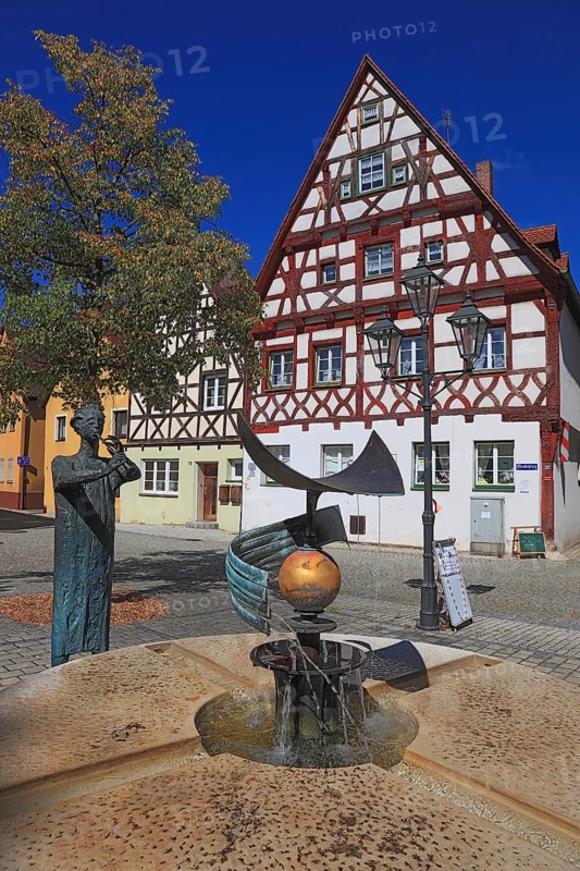 Half-timbered houses and fountain figure flute player, on Rathausplatz, city of Heideck in the district of Roth, Middle Franconia, Bavaria, Germany