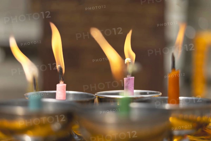 Oil lamps lit by believers as a symbol of the light of wisdom (the light dispels darkness and ignorance) in front of a Buddha statue, Wat Yannawa in the Sathon district, Bangkok, Thailand
