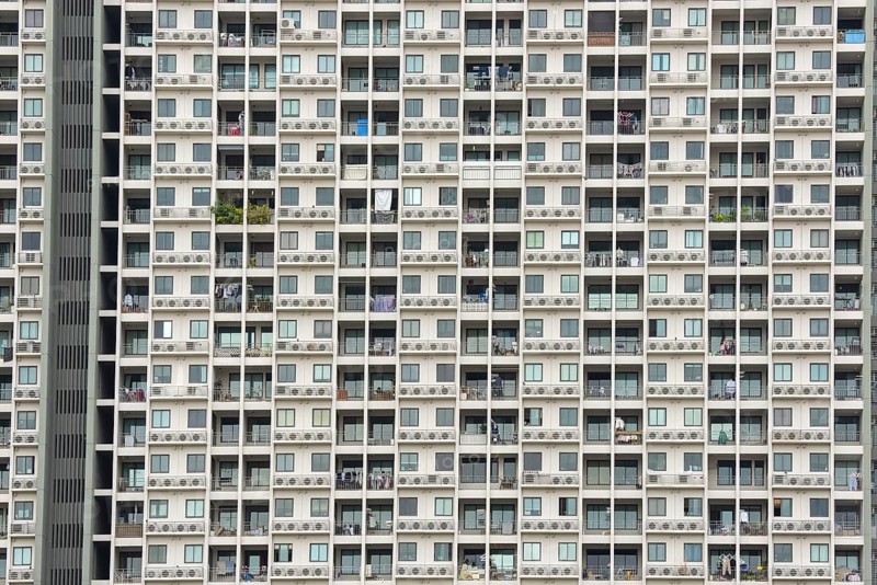 Exterior façade of a residential high-rise building of Condo U (a brand or series name of the Thai real estate developer Grand Unity Development Co., Ltd. (often abbreviated Grand U), Bangkok Yai district, the old town of Bangkok, Thailand