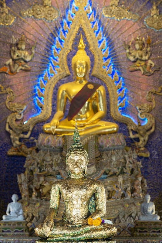 Buddha statue decorated with gold leaf, Bhumispara mudra, Buddha Gautama at the moment of enlightenment, behind another golden Buddha statue with tunic, art hall with modern art trends such as minimalism and abstraction, Wat Pariwat, Yan Nawa district, Bangkok, Thailand