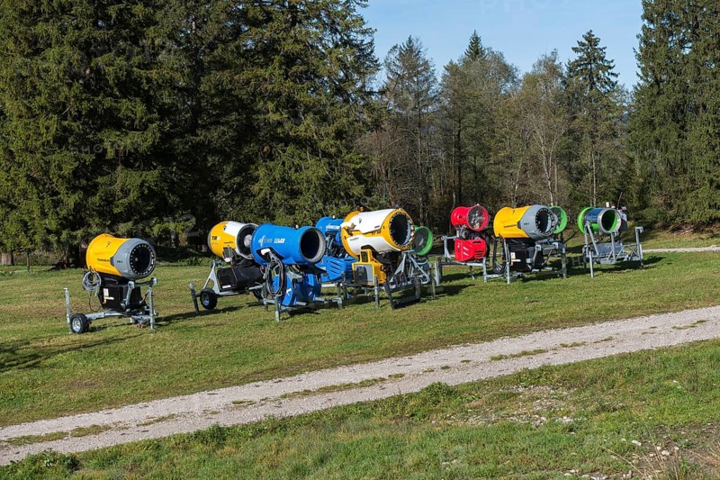 Row of snow cannons in a meadow in front of trees and blue sky, Schwangau near Füssen, Ostallgäu, Allgäu, Bavaria, Germany