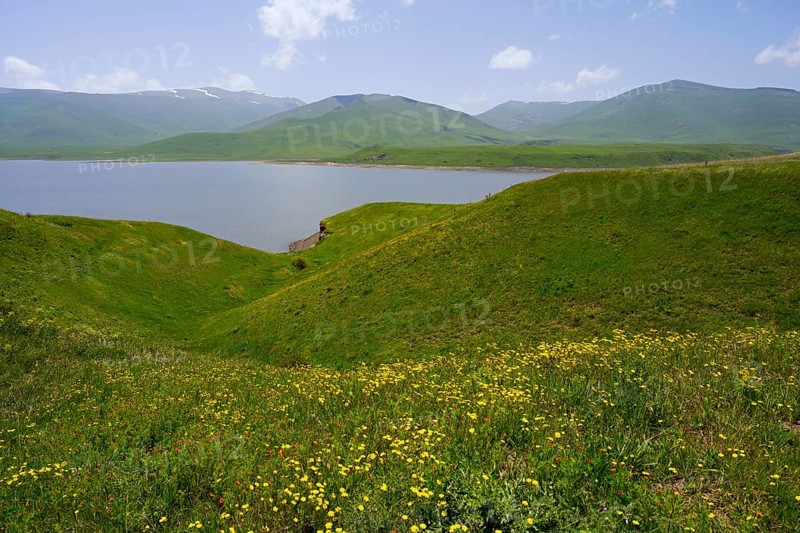 Green hills surround a calm lake under blue sky, spring-like atmosphere, Spandaryan Reservoir, Spandarian, fed by the Vorotan River, Vorotan, Syunik Province, Armenia
