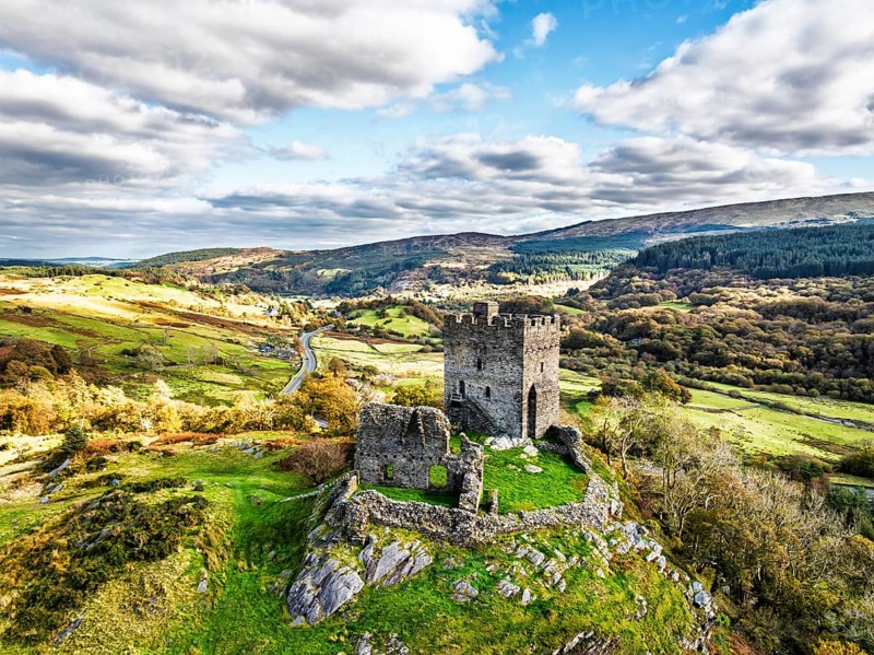 Autumn colours over Castell Dolwyddelan and Eryri Mountains from a drone, Snowdonia, Conwy County Borough, Wales, England, United Kingdom