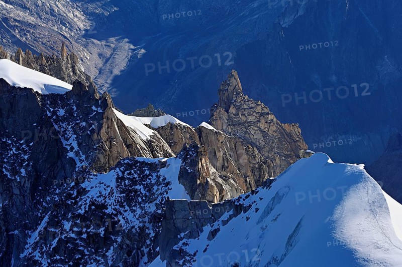 Rugged rocks jut out of a snow-covered mountain, viewing platform, Aiguille du Midi mountain station, Chamonix-Mont-Blanc, Haute-Savoie, France