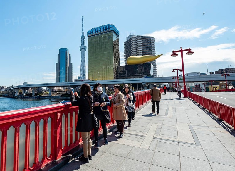 Visitors on the Azuma Bridge, Sumida City Skyline, Sumida City Office, Tokyo Skytree, Asahi Beer Hall and Asahi Headquarters with Asahi Flame, Asakusa, Tokyo, Japan