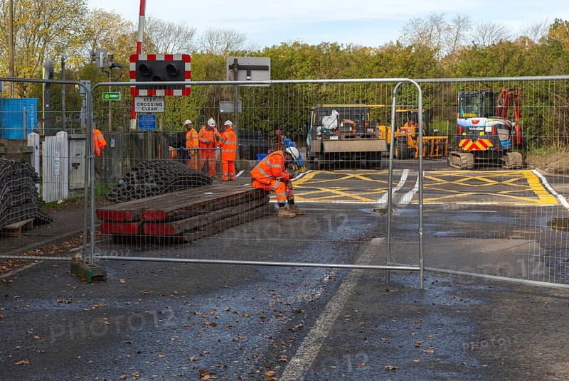 Road and rail level crossing closed, Network Rail railway line upgrade maintenance, Melton, Suffolk, England, UK autumn 2025