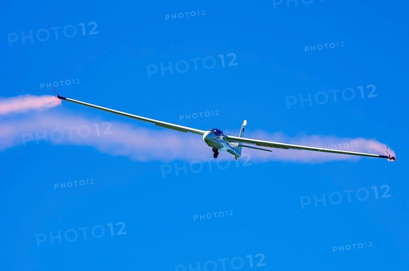 An SZD-59-1 ACRO glider, registration D-1138, during a demonstration as part of an air show at the Fliegerbergfest of the Rossfeld Luftsportverein in Metzingen-Glems, Baden-Württemberg, Germany, for editorial use only
