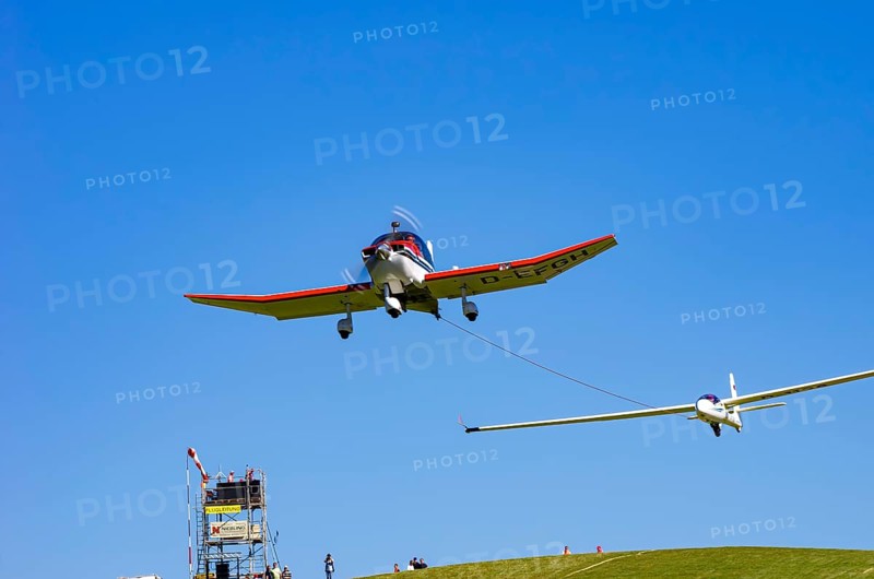 A Robin DR 400/200R Remorqueur light aircraft, registration D-EFGH, tows a glider during a flight demonstration as part of an air show on Rossfeld in Metzingen-Glems, Baden-Württemberg, Germany, for editorial use only