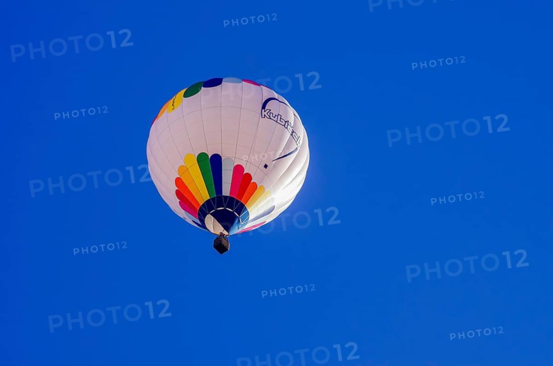 A hot air balloon, registration D-OÖJ, rises into the air as part of an air show at the Fliegerbergfest of the Rossfeld Luftsportverein in Metzingen-Glems, Baden-Württemberg, Germany, for editorial use only