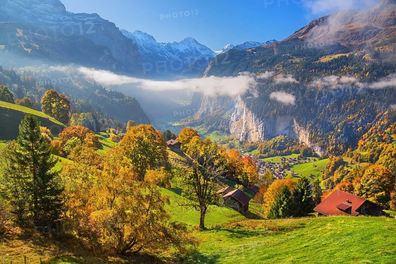 View from the village of the Lauterbrunnen Valley with Staubbach waterfall in autumn with morning fog, Wengen, Bernese Oberland, Canton of Bern, Switzerland
