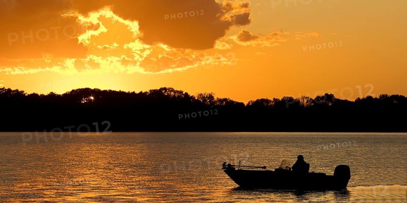 A boat on Lake Gudelack at sunset, Lindow (Mark), Stechlin-Ruppiner Land nature park Park, Brandenburg, Germany