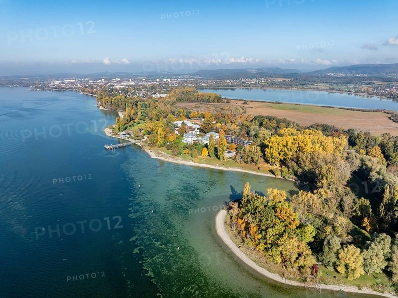 Aerial view of the Mettnau peninsula, surrounded by autumn vegetation, in western Lake Constance with the spa center, Mettnaukur, boat dock and restaurant Strandcafe, Radolfzell, Konstanz district, Baden-Württemberg, Germany