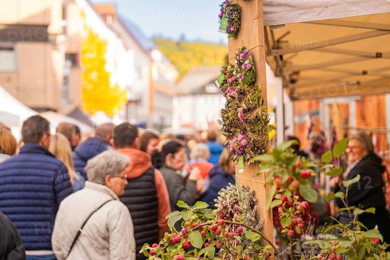 Busy shopping street in autumn, people strolling between modern buildings and colorful shops, Urschelherbst street festival, Nagold, Germany
