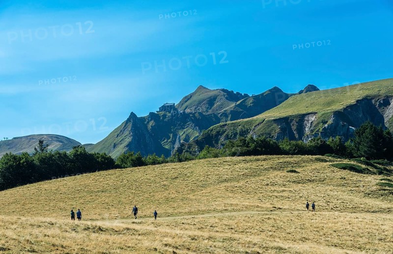 Auvergne Volcanoes Regional Park. Groups of hikers traverse a rugged path in the beautiful Sancy Massif region, Puy de Dome, Auvergne, France