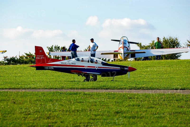 An RC model of a Pilatus PC-21 with advertising for the Swiss watch brand Breitling during a flight demonstration as part of an air show at the Rossfeld in Metzingen-Glems, Baden-Württemberg, Germany, for editorial use only