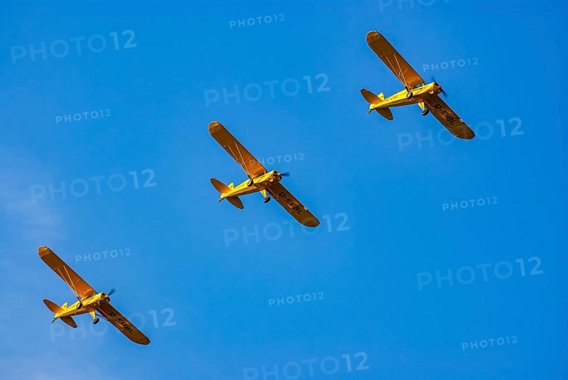 Three Piper PA-18 Super Cub aeroplanes of the Bravo Lima Formation flying in formation during an air show at the Rossfeld in Metzingen-Glems, Baden-Württemberg, Germany, for editorial use only