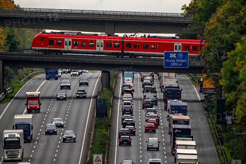 Local train crossing the A3 motorway between the Hilden junction and the Mettmann junction, view to the south, traffic jam due to construction work, North Rhine-Westphalia, Germany