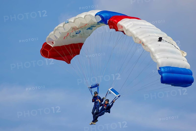 Two parachutists during an aerial acrobatic performance as part of an air show at the Rossfeld in Metzingen-Glems, Baden-Württemberg, Germany, for editorial use only