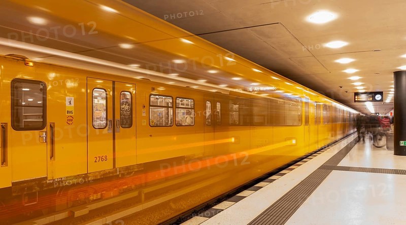 Dynamic scene of a Berlin underground in typical yellow colour, long exposure with blur effect, busy traffic junction at Unter den Linden station, Berlin, Germany