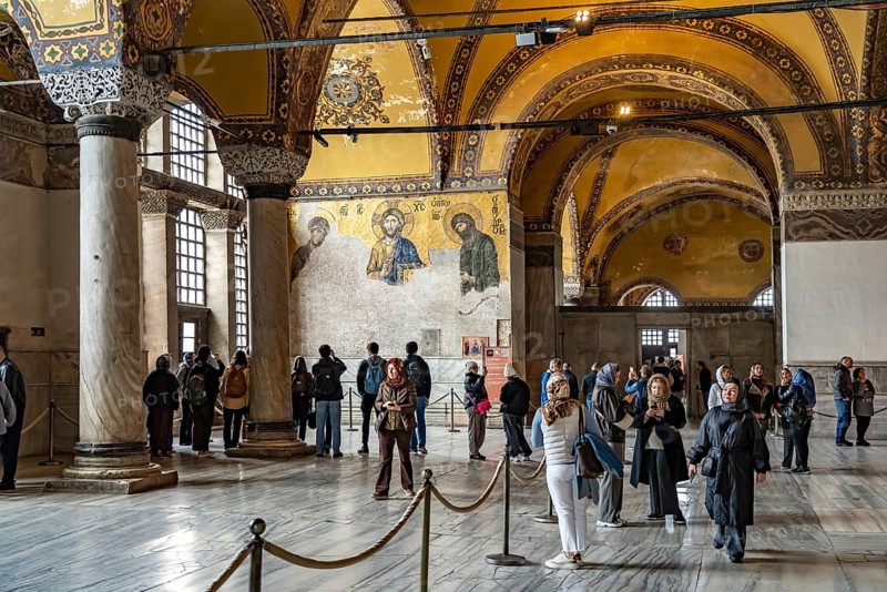 Visitors at the Deësis mosaic in the interior of today's Hagia Sophia mosque or Church of St Sophia, former Byzantine church and museum in Istanbul, Turkey