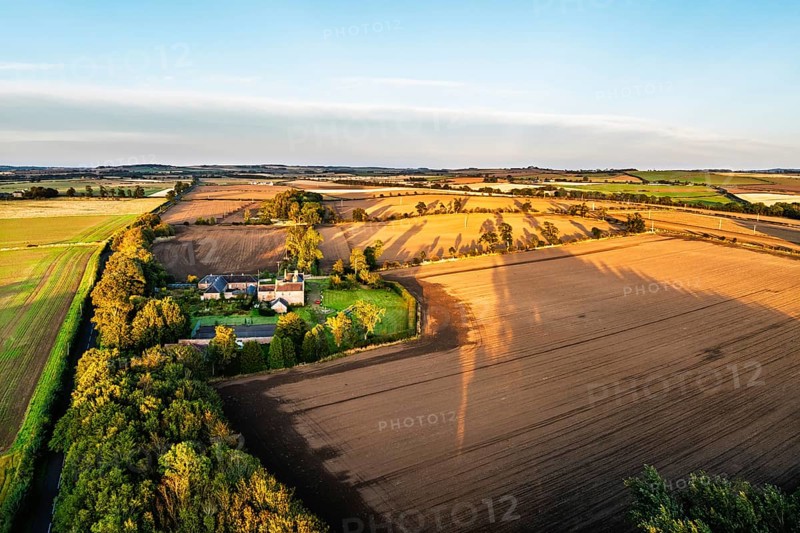 Sunset of Farms and Fields over Norham Castle from a drone, Norham, River Tweed, Northumberland, England, United Kingdom