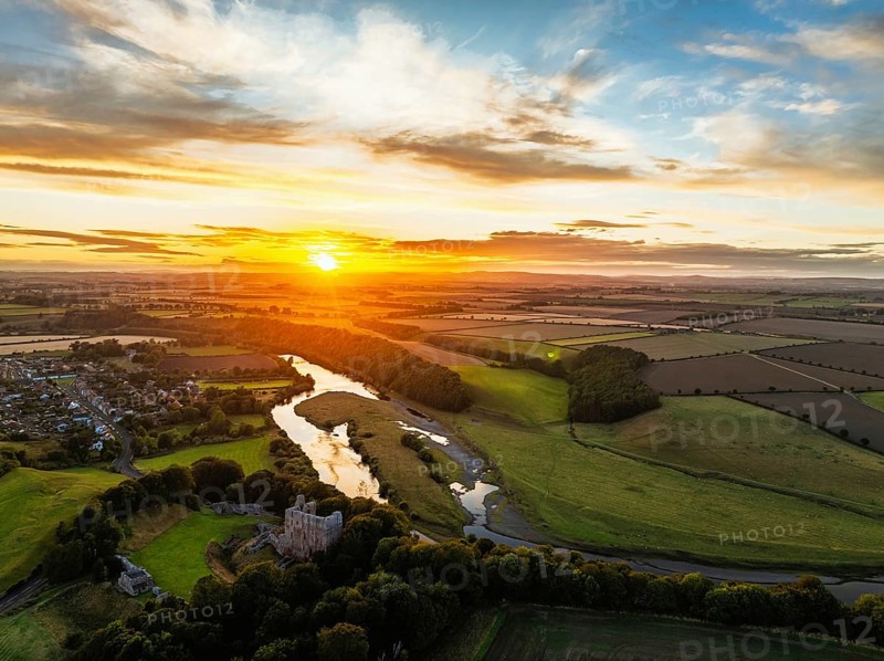 Sunset over Norham Castle and River Tweed from a drone, Norham, Northumberland, England, United Kingdom