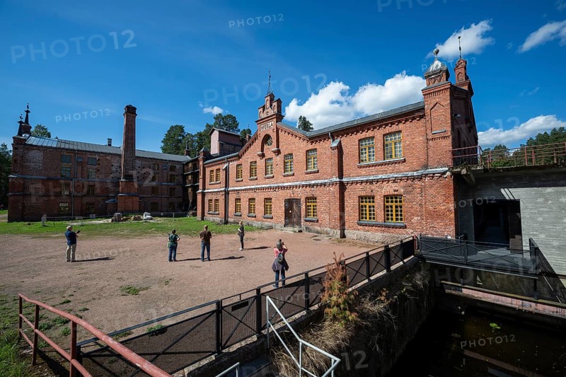 Visitors in front of the former paper mill and groundwood pulp board mill, UNESCO World Heritage Site Verla Factory Village, Maailmanperintökohde Verlan puuhiomo ja pahvitehdas, Verla Rapids, Kymenlaakso, near Kouvola, Finland