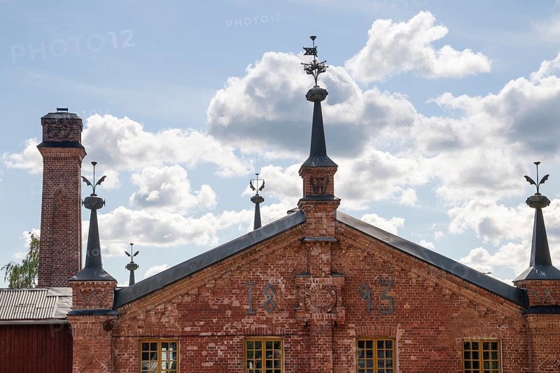 Brick building with weather vane and chimney, former paper mill for the production of groundwood pulp board, UNESCO World Heritage Site Factory Village Verla, Maailmanperintökohde Verlan puuhiomo ja pahvitehdas, Verla Rapids, Kymenlaakso, near Kouvola, Finland