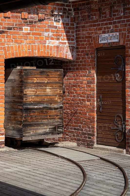 Old wooden trolley on rails, brick wall, former paper mill for the production of groundwood pulp board, UNESCO World Heritage Site Verla Factory Village, Maailmanperintökohde Verlan puuhiomo ja pahvitehdas, Verla Rapids, Kymenlaakso, near Kouvola, Finland