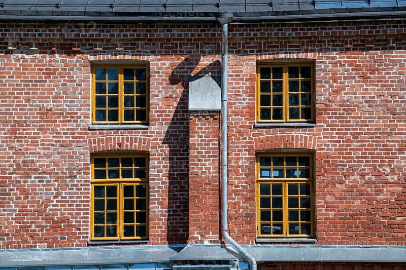 Brick façade with yellow window frames, former paper factory and mill for the production of groundwood pulp board, UNESCO World Heritage Site Factory Village Verla, Maailmanperintökohde Verlan puuhiomo ja pahvitehdas, Verla Rapids, Kymenlaakso, near Kouvola, Finland